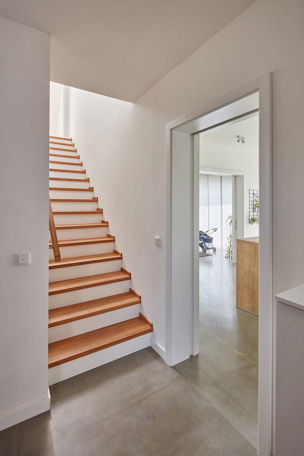 Weißes Treppenhaus mit hellen Holzstufen