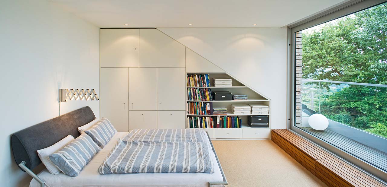 In die Dachschrägen eingepasste Schrank- und Regalelemente in einem modernisierten Reihenhaus.