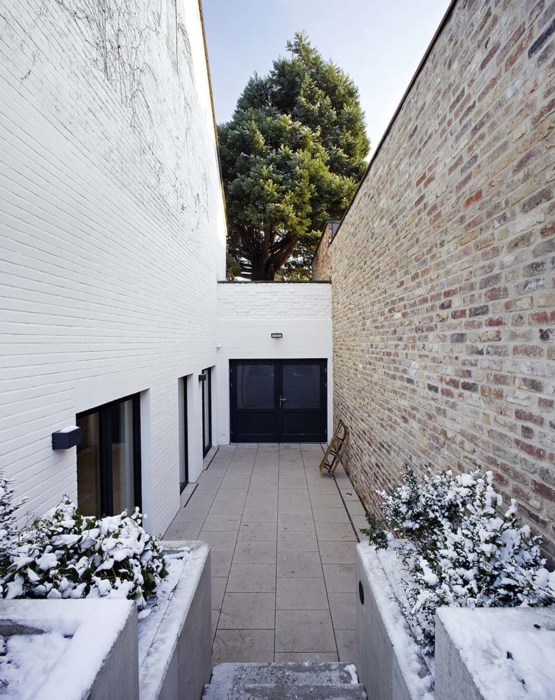 Blick in den Kinderspielhof mit verschneiten Sträuchern.