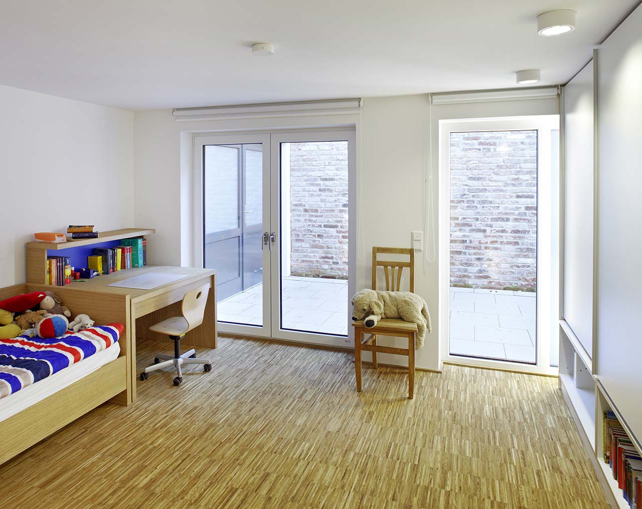 Kinderzimmer mit großen Fenstertüren nach draußen.