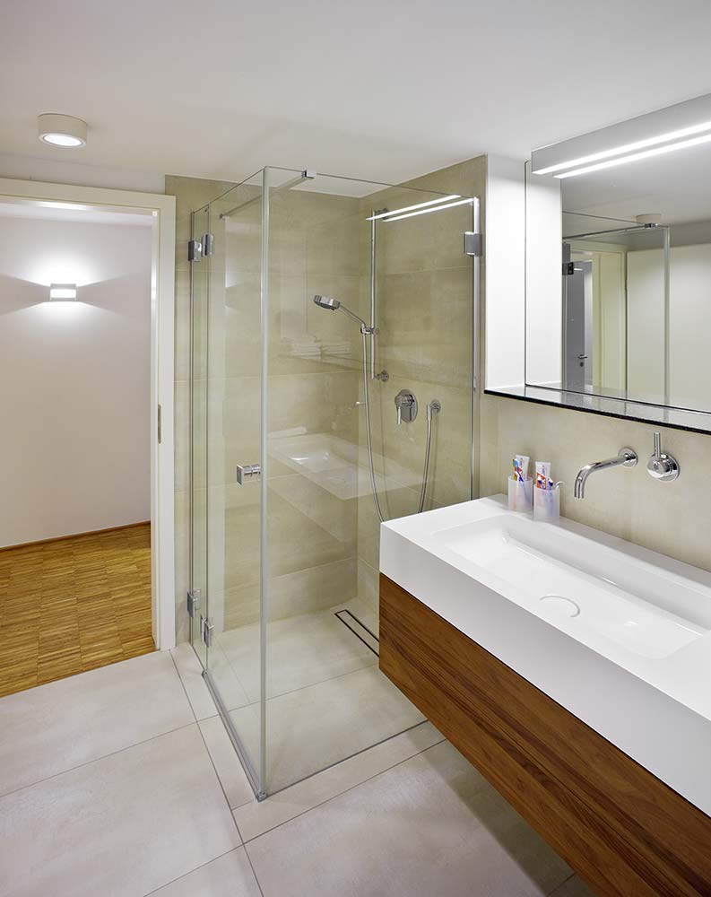 Badezimmer mit bodentiefer vollverglaster Dusche.