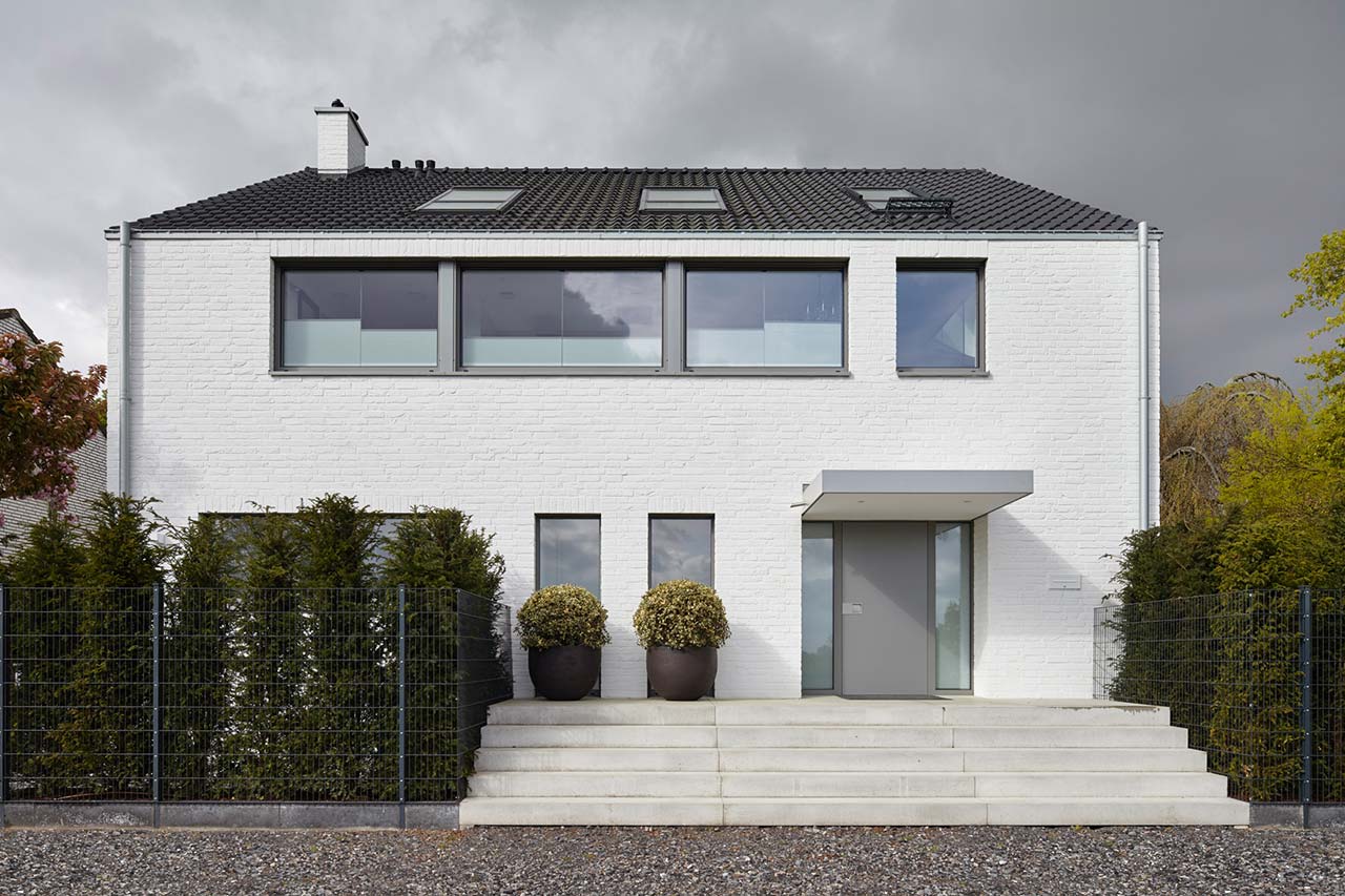 Zweifamilienhaus aus den 60er Jahren nach Umbau und Modernisiereung, mit weißer Fassade und großen Fenstern.