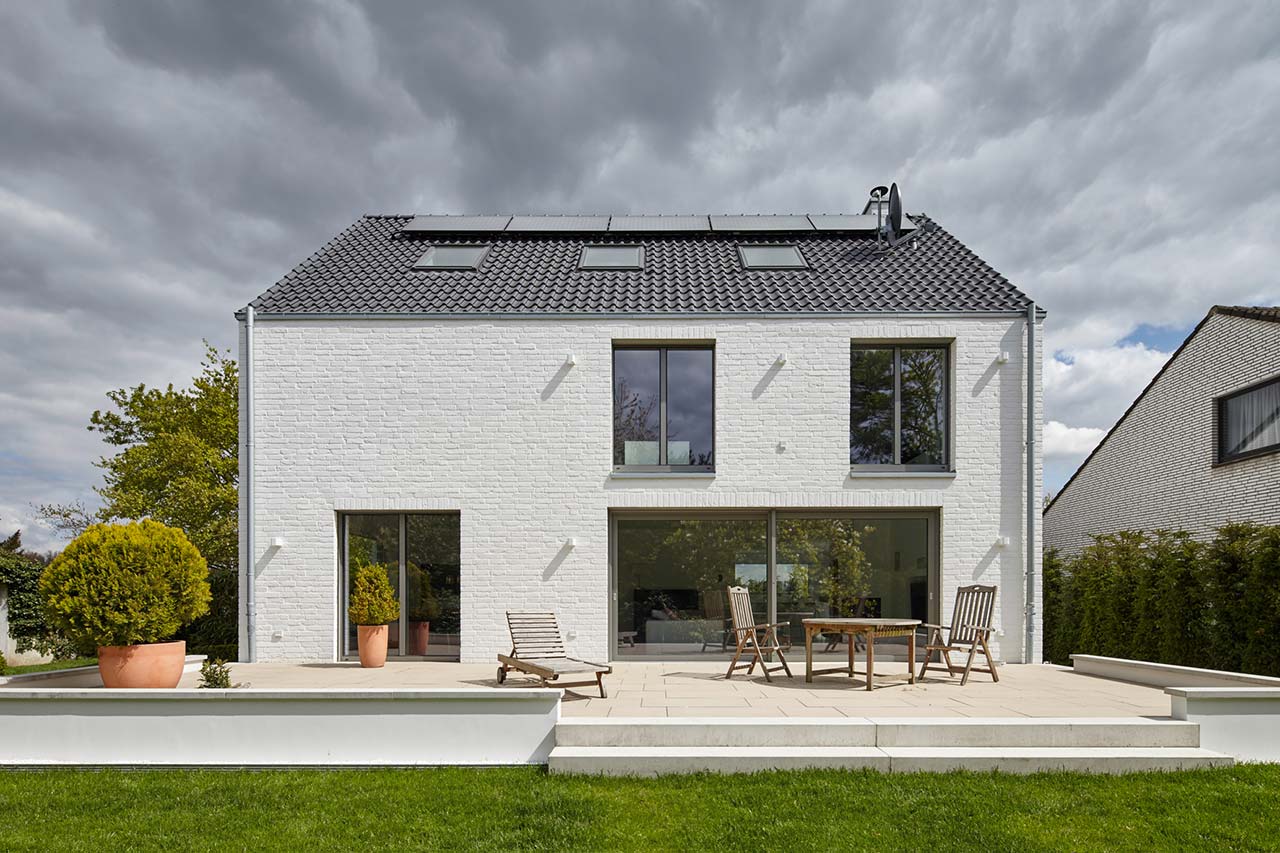 Umgebautes Zweifamilienhaus aus den 60er Jahren miot Terrasse und großen Fenstern.