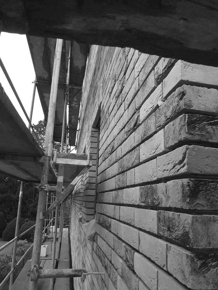 Baugerüst an einer Backsteinfassade.