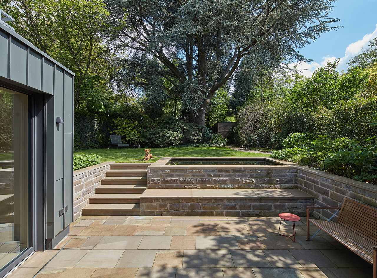 Terrasse mit stein-Ummauerung und Treppe zum erhöht gelegenen Garten