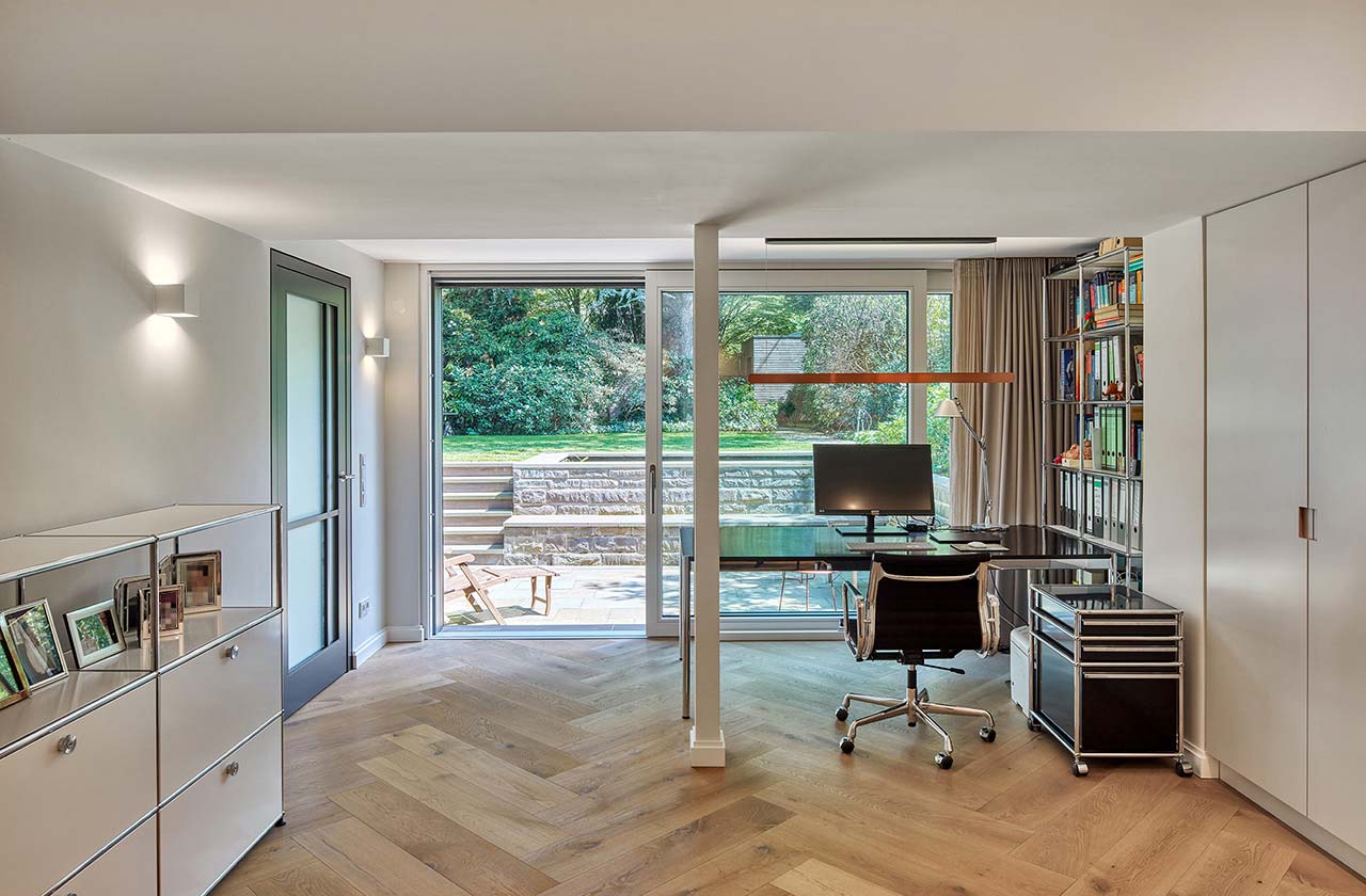 Heller, moderner Arbeirsraum im Souterrain mit Fenstertürenfront zur Terrasse