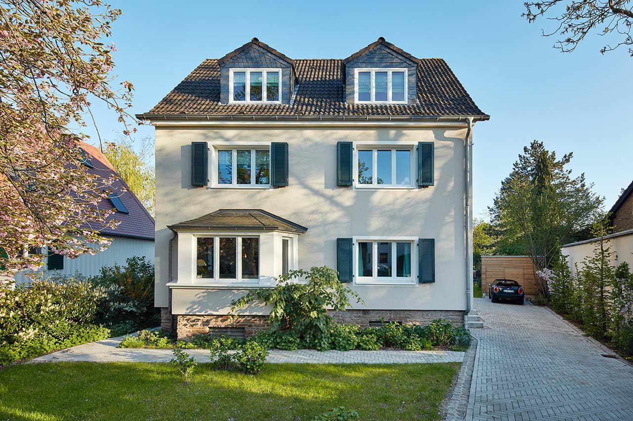 Fassade eine Stadthauses aus dem Jahr 1937 mit Vorgarten und seitlicher Einfahrt.