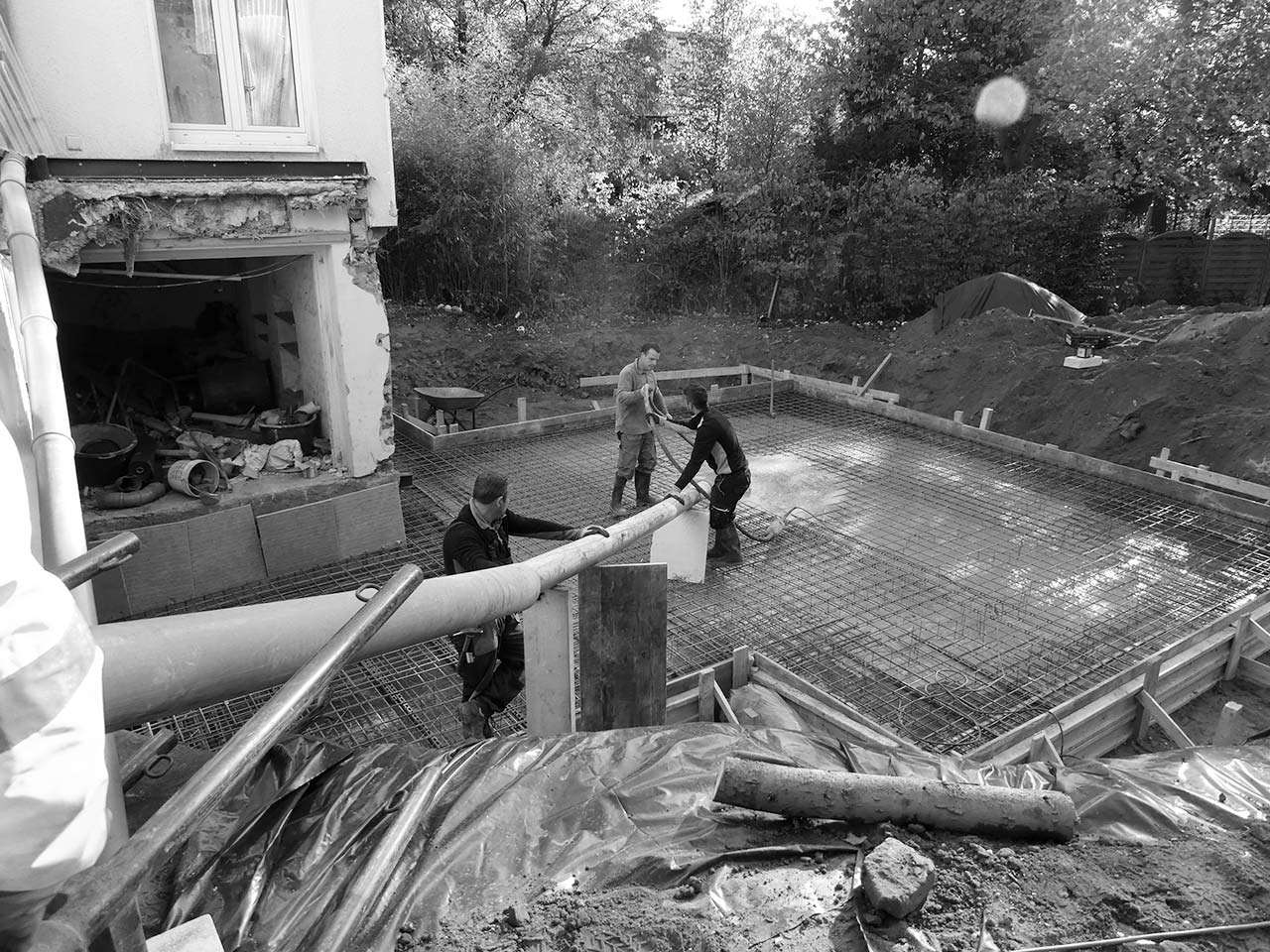 Arbeiter gießen eine Stahlbeton-Bodenplatte.