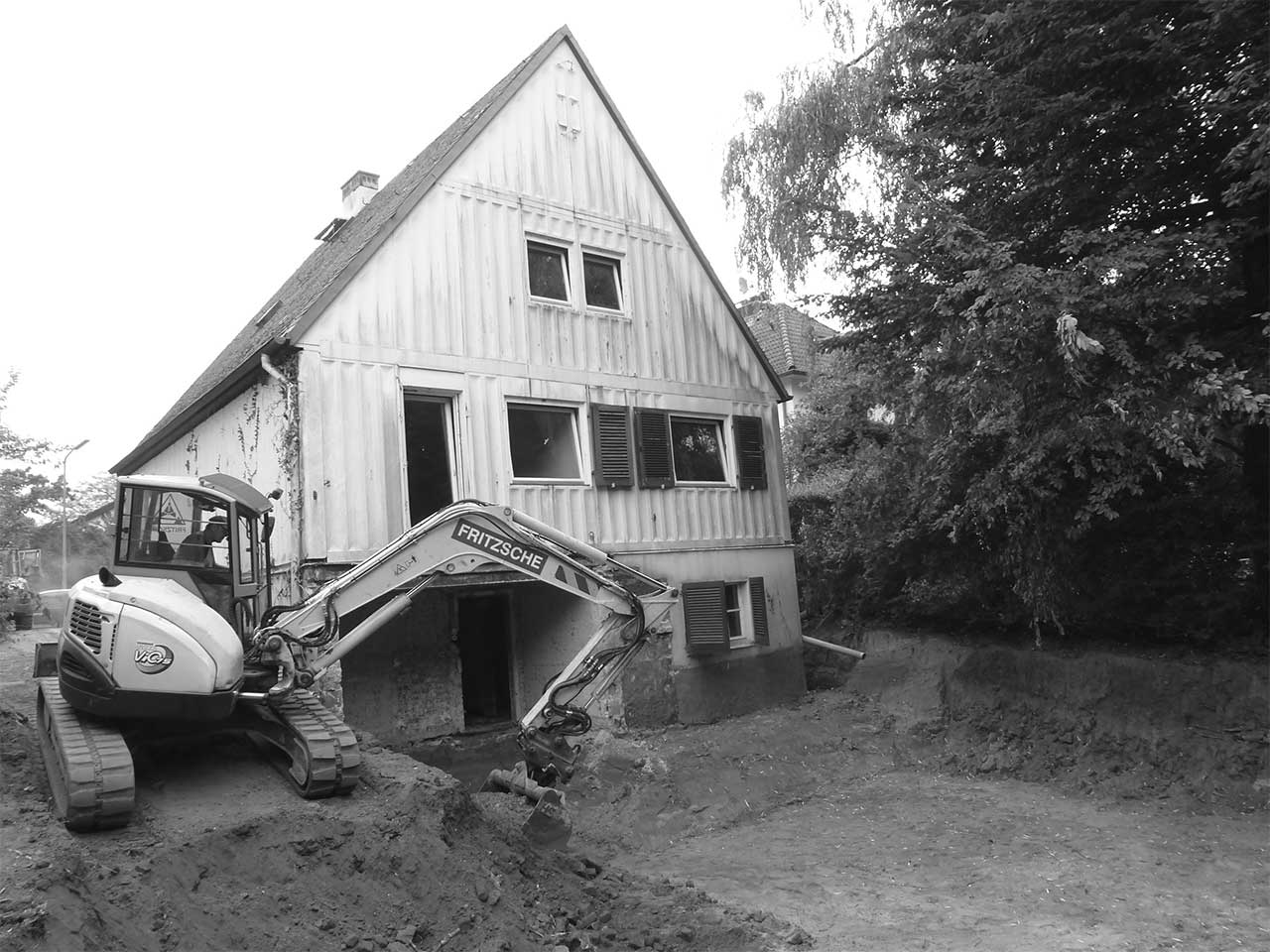 Ein Bagger schachtet den Bereich hinter dem alten Stahlhaus aus.