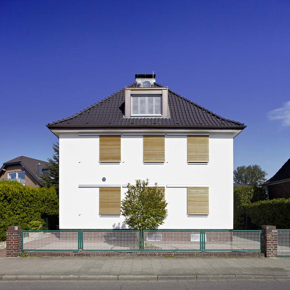 Die Fassade mit geschlossenen Holz-Schiebeläden.