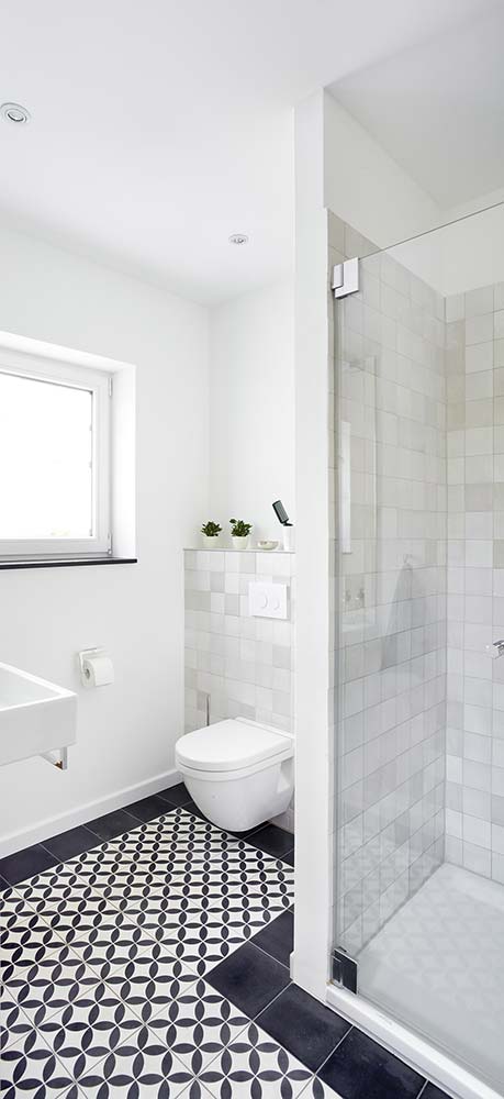 Modernisiertes Badezimmer mit zeitgenössischem gemusterten Fliesenboden.