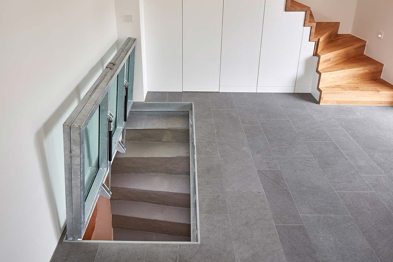 Geöffnete Glasabdeckung zur Kellertreppe.