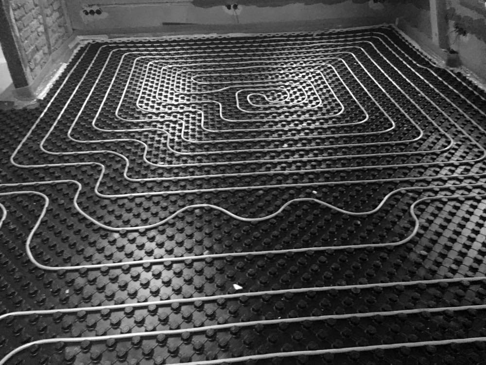 Verlegung einer Fußbodenheizung in einem alten Haus.