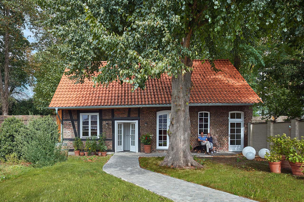 Das Ateliergebäude mit Sprossenfenstern und -türe in der Fachwerk-Backsteinfassade.