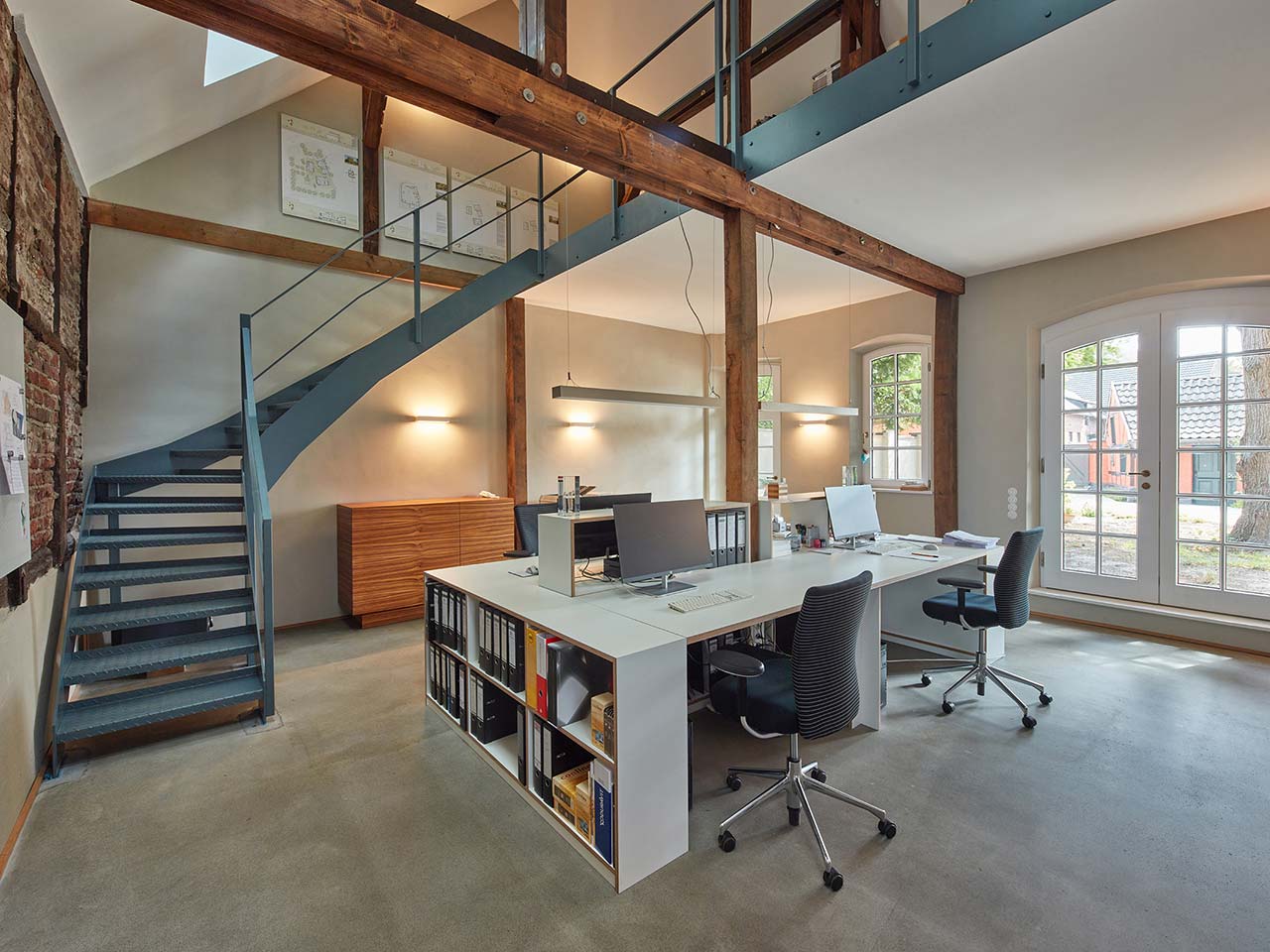 Geschwungene grüne Stahltreppe zur Galerie über dem Büro.