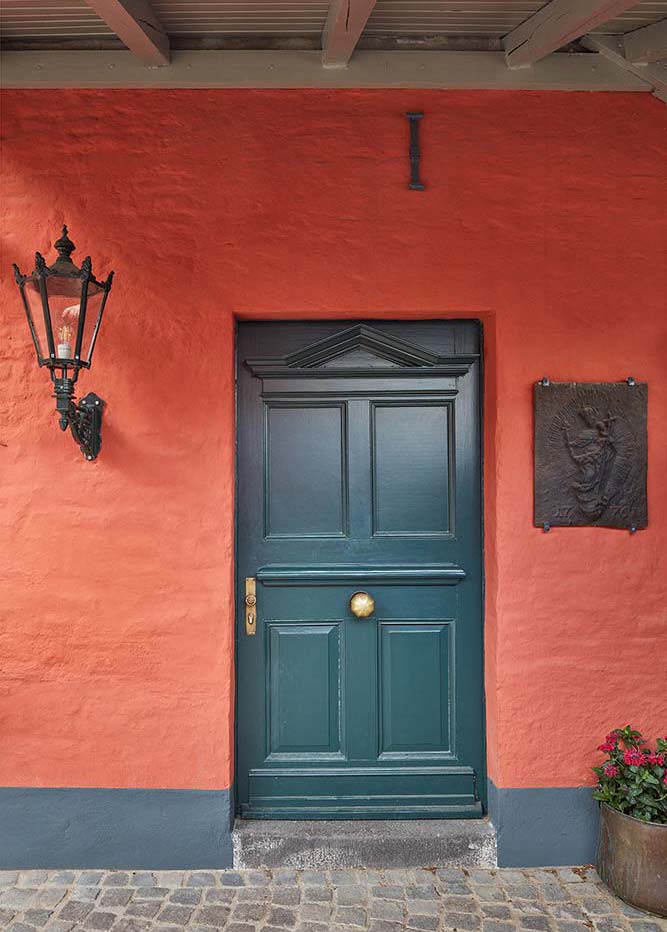 Dunkelgrün lackierte Eingangstür mit Messingbeschlägen.