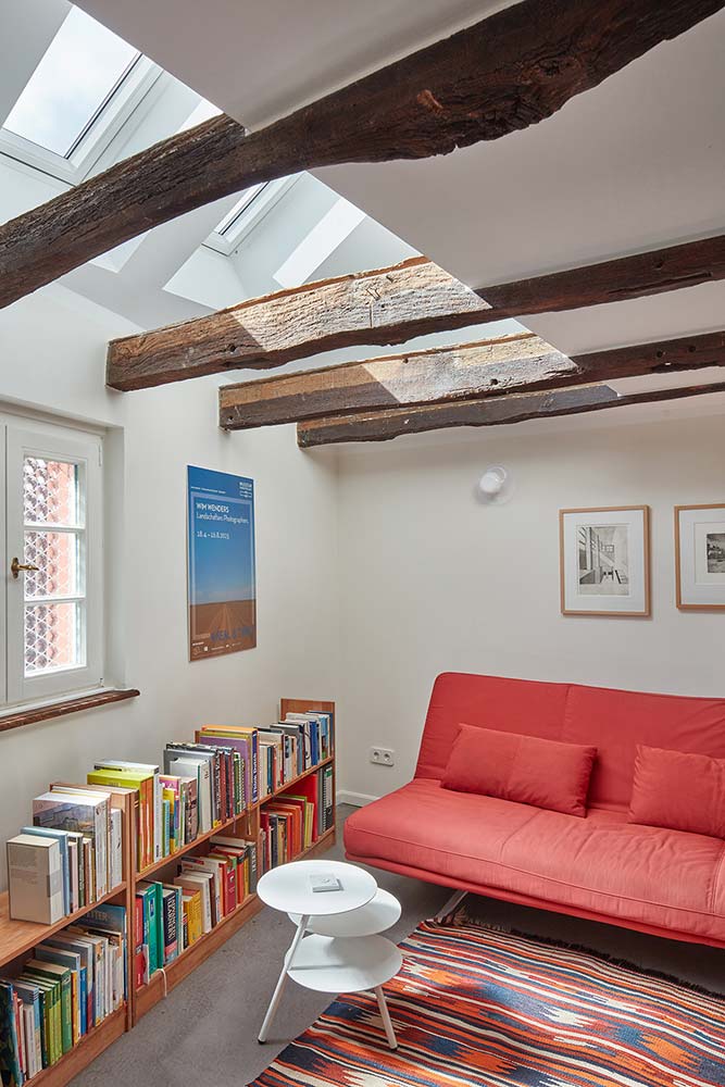 Geöffnete Decke mit sichtbaren Dachbalken und großzügigen Dachfenstern.