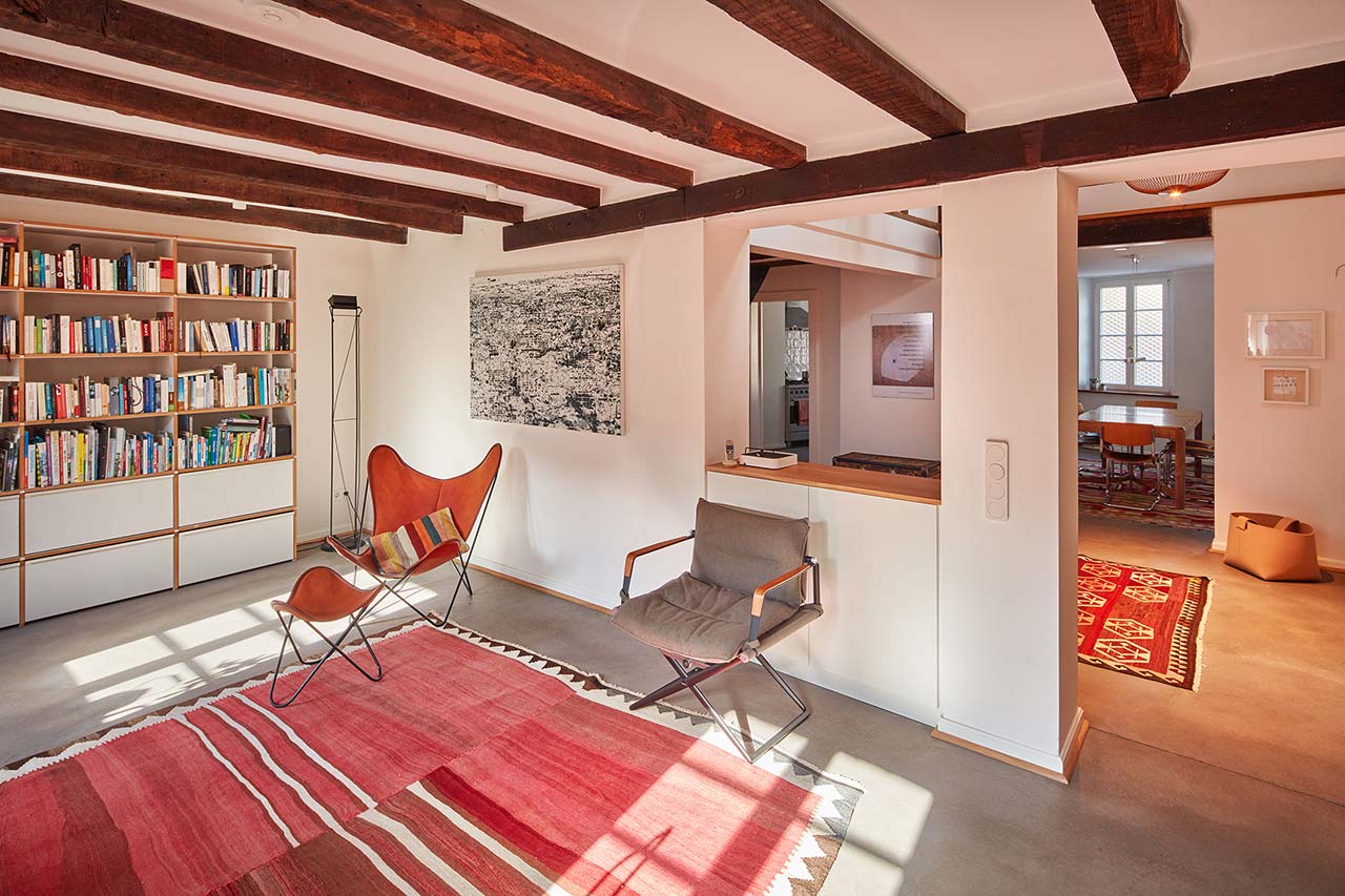 Wohnraum mit Balkendecke und Durchgang zur Eingangshalle und zum Essbereich.