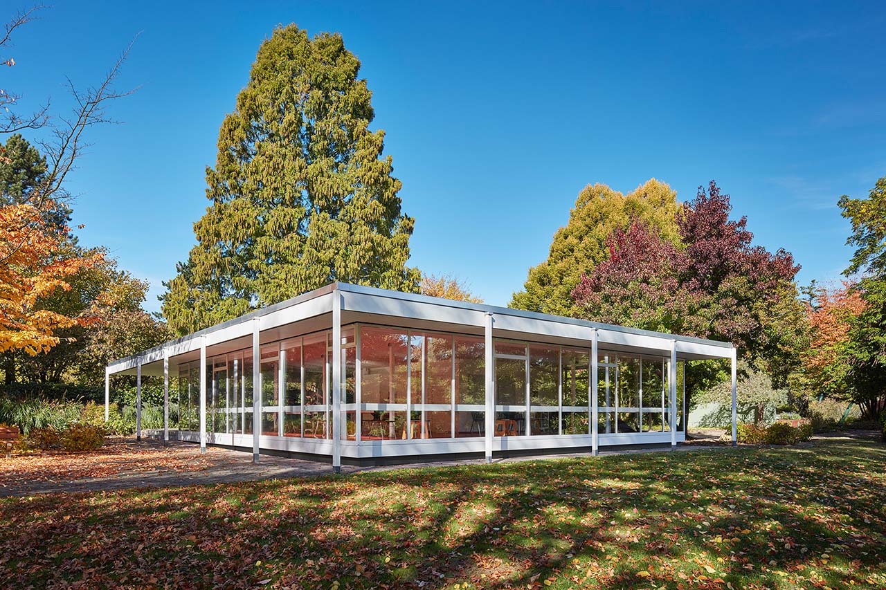 Gläserner Lesepavillon der GRUGA in Essen, inmitten von herbstlichen Bäumen.