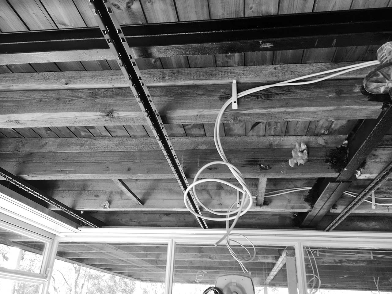 Baustellendetail der Verkabelung unter einer Holzdecke.