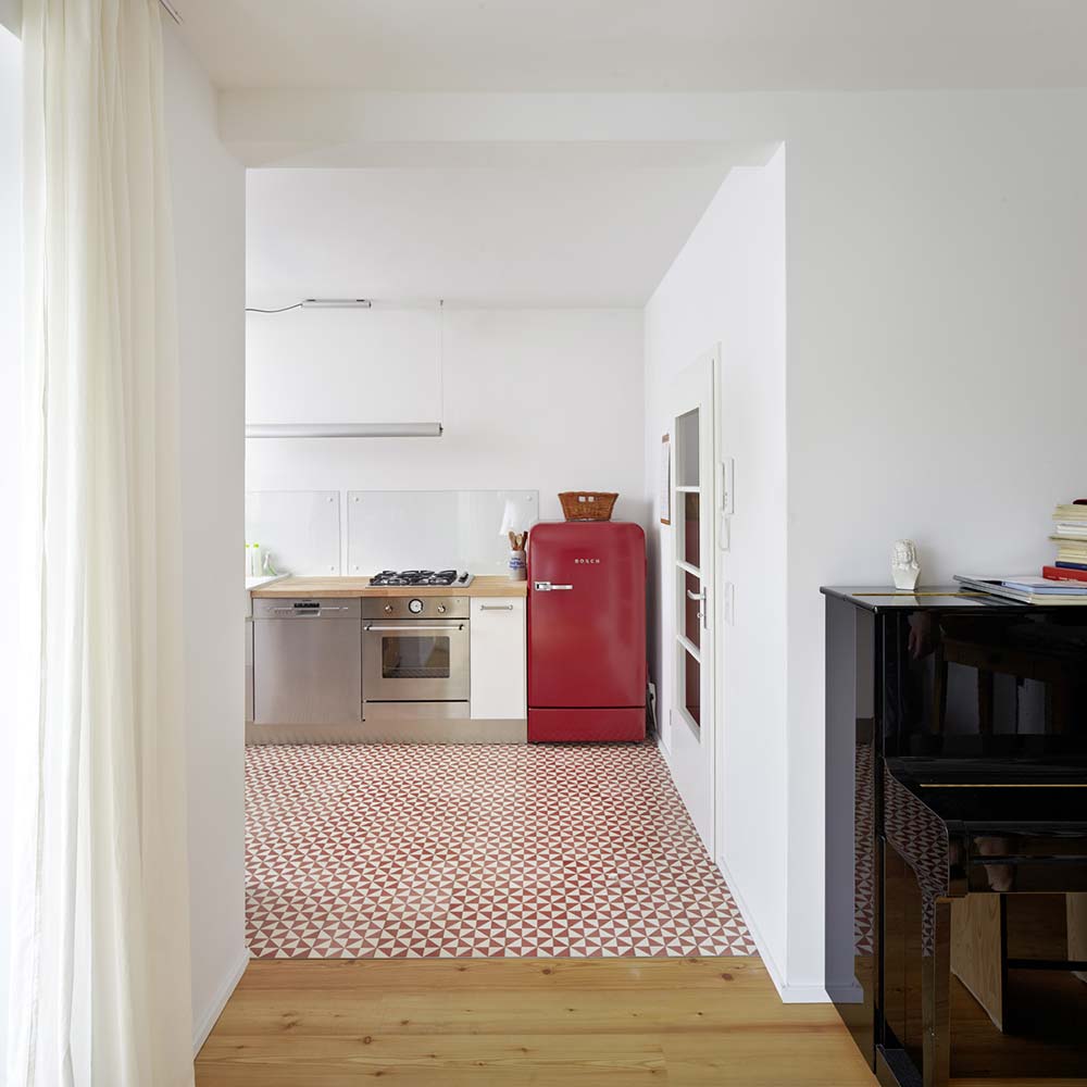 Moderne Küche im sanierten Reihenendhaus aus den 20er Jahren mit rotem Kühlschrank.