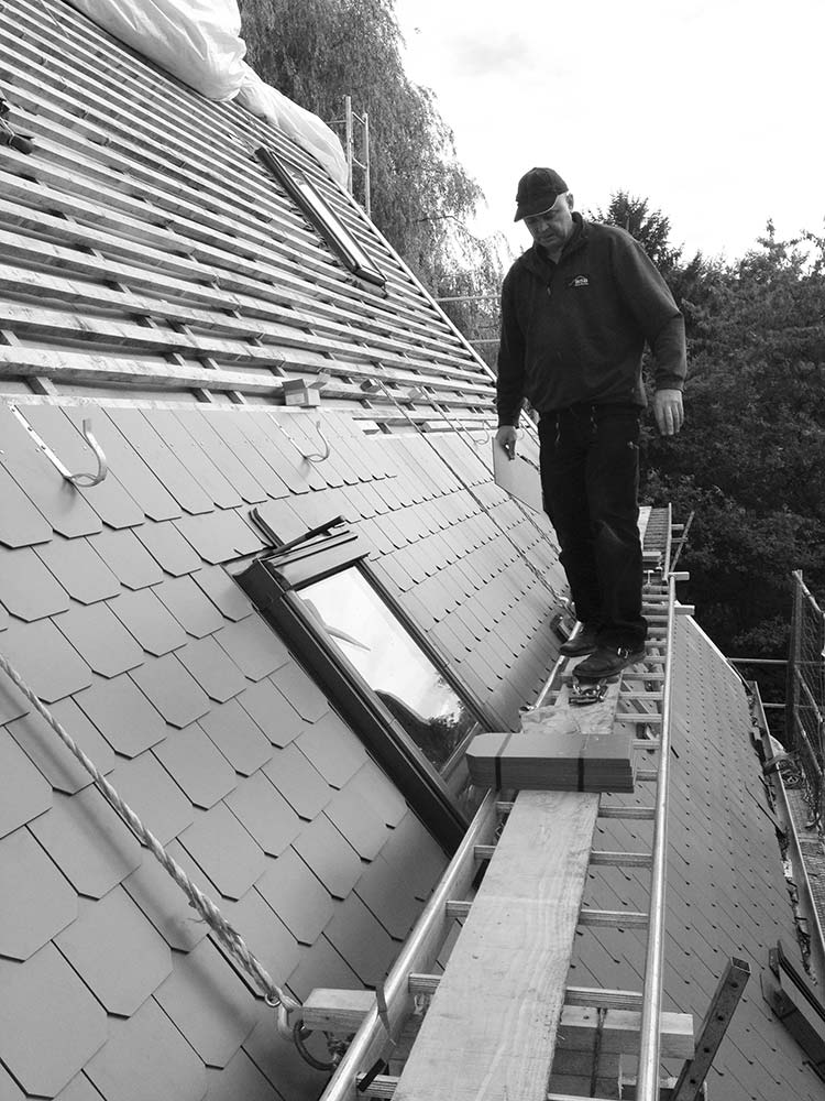 Arbeiter auf einem Gerüst beim Neubau des Daches.