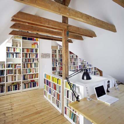 Dachgeschoss-Sanierung und -Umbau mit Bücherregalen und freiliegenden Deckenbalken