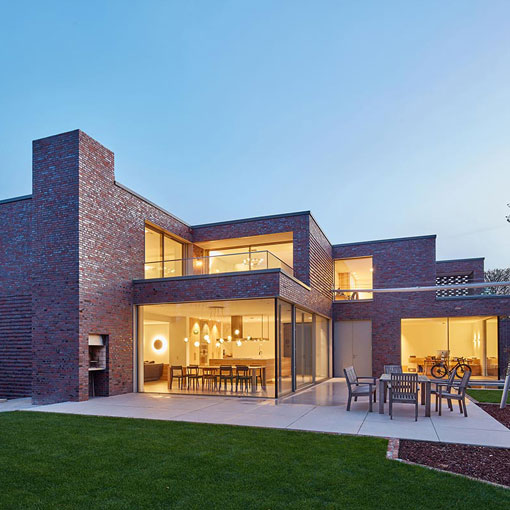 Baustelle eines modernen Einfamilienhauses mit Baugerüst und Baumaterial